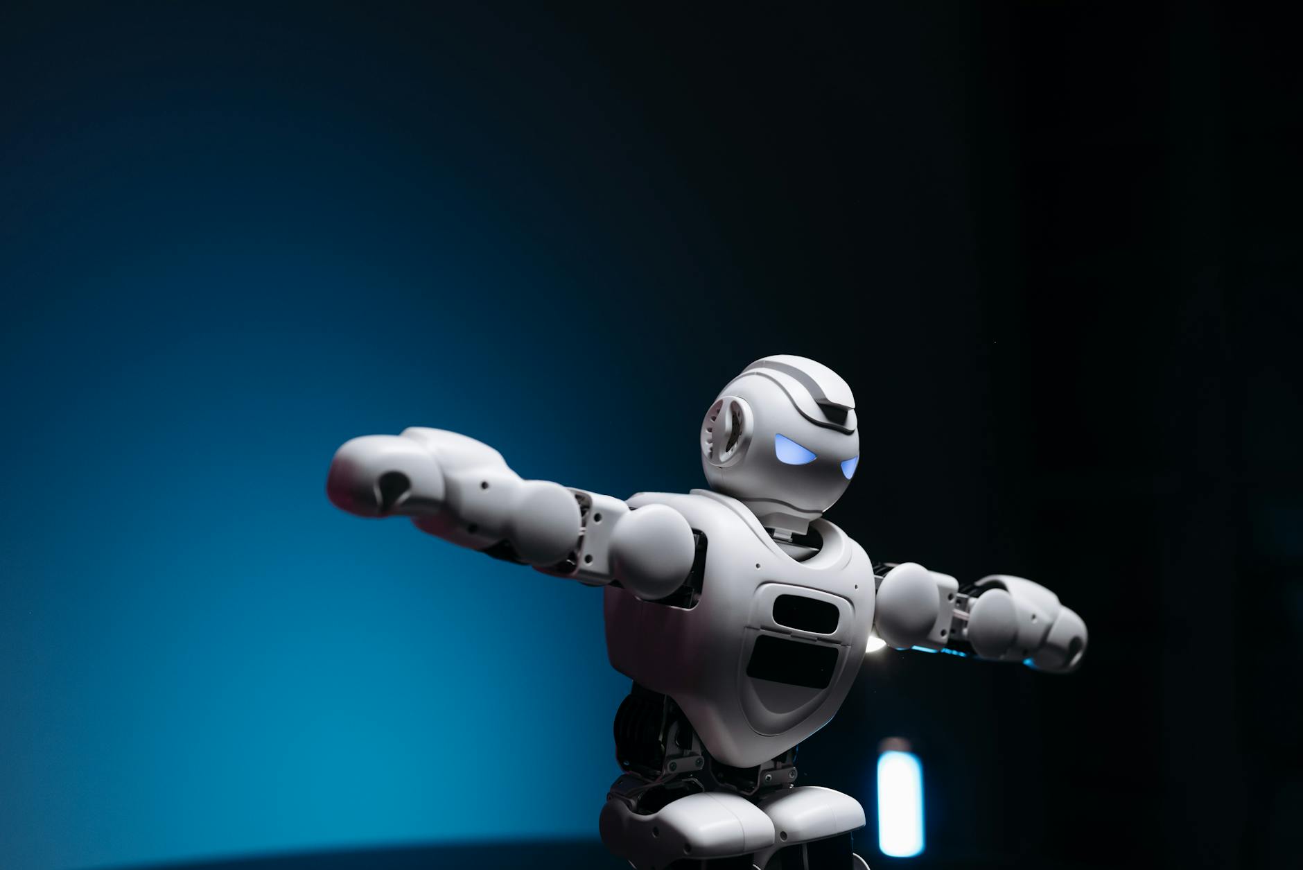 close up shot of white toy robot on blue background